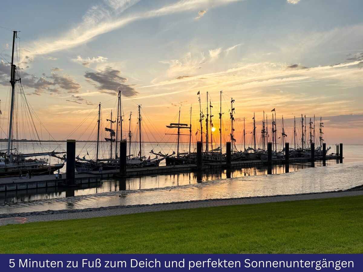 A marina with multiple boats docked at wooden piers during sunset.
