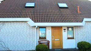 Ein zweistöckiges Haus mit einem Ziegeldach, einer Haustür und zwei kleinen Fenstern.