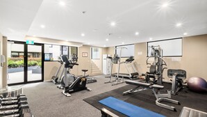 Una palestra con tapis roulant, ellittiche, panche pesi e palle per esercizi.