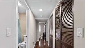 A hallway with a toilet, a sink, and a shower area. - Peaceful 2-bedroom apartment - Walk Everywhere (Philadelphia)
