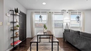 A modern living room with a sofa, a dining table, and a bookshelf. - Peaceful 2-bedroom apartment - Walk Everywhere (Philadelphia)
