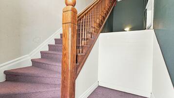 A wooden staircase with a handrail leading to a landing.