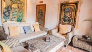 A living room with a sofa, armchairs, a coffee table, and decorative wall art. - Kintamani 7-Bedroom House in Pattaya. (Banglamung)