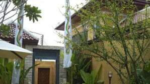 A courtyard with a stone entrance, surrounded by lush greenery and a white umbrella. - Kintamani 7-Bedroom House in Pattaya. (Banglamung)