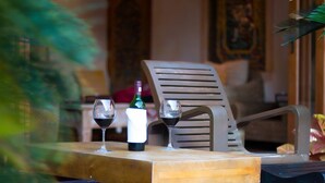 A wooden table with two wine glasses and a bottle of wine. - Kintamani 7-Bedroom House in Pattaya. (Banglamung)