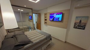 Ein Hotelzimmer mit zwei Betten, einem an der Wand befestigten Fernseher und einem New York City Plakat.