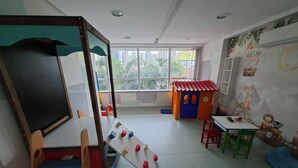 Ein Klassenzimmer mit einer Tafel, einem Spielbereich und lehrreichen Wandbildern.