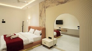 Ein modernes Hotelzimmer mit einem Bett, einem Nachttisch, einem Spiegel und einem an der Wand montierten Fernseher.