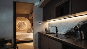 Eine moderne Küche mit Einbauherd, Kaffeemaschine und einer eleganten Arbeitsplatte.
