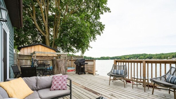 A deck with a sofa, chairs, and a grill. - Scenic Waterfront Cottage Retreat - Firepit & BBQ (Hanover)
