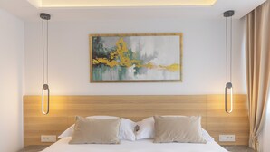 A modern hotel room with a wooden headboard, a large bed with two pillows, a wall-mounted abstract painting, and a ceiling light fixture. - Stay in a luxury apartment near Diocletian's Palace (Split)