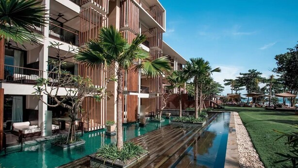 Un hôtel moderne doté d’une piscine, d’un espace extérieur aménagé et d’une végétation luxuriante.