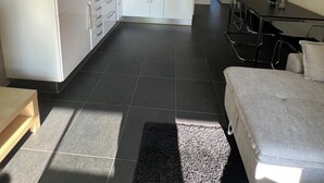A modern kitchen with white cabinets, a central island, and a dining area with a table and chairs. - Natural paradise for hikers & cyclists Aachen border triangle (La Calamine)