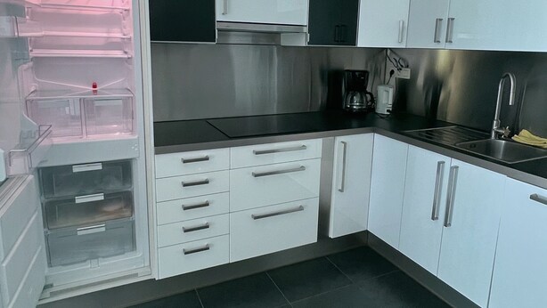 A kitchen with white cabinets, a stainless steel range hood, a sink, and a coffee maker. - Natural paradise for hikers & cyclists Aachen border triangle (La Calamine)