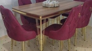 A dining table with six chairs, each with a unique design.