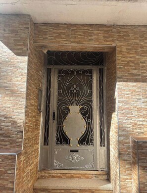A door with intricate metalwork and a decorative panel, set in a stone wall. - A special  Apartment for rent today (Casablanca)