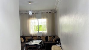A living room with a sofa set, a coffee table, a rug, and a bench.