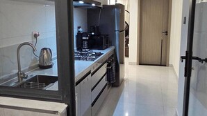Een moderne keuken met een roestvrijstalen spoelbak, een koffiezetapparaat en een fornuis.