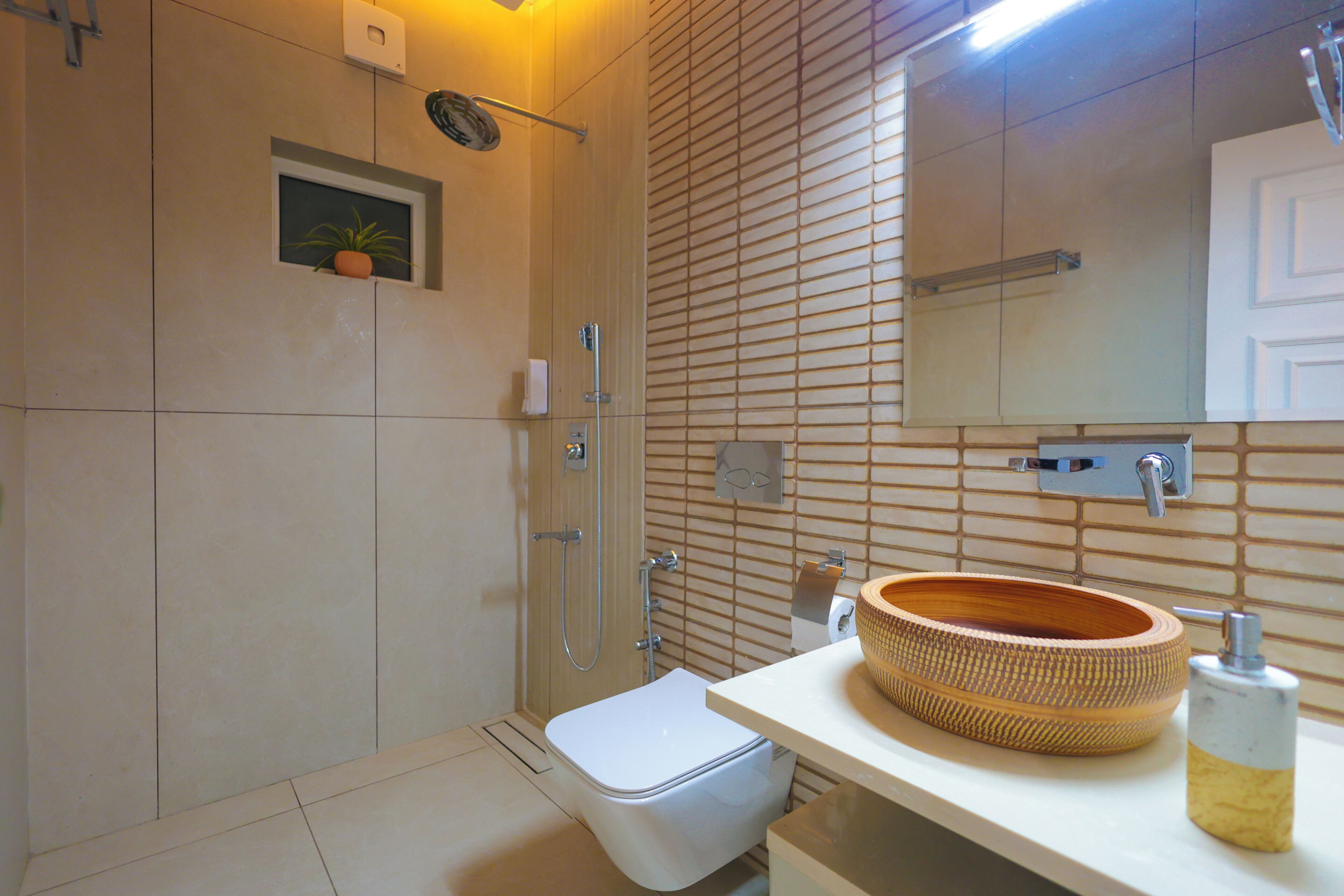 A modern bathroom with a toilet, a shower, and a sink with a wooden bowl.