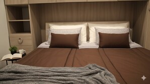 A neatly made bed with brown bedding, a bedside table with a book and a cup, and a small plant. - A due passi dagli Scavi con parcheggio gratuito e Wi-Fi (Pompei)