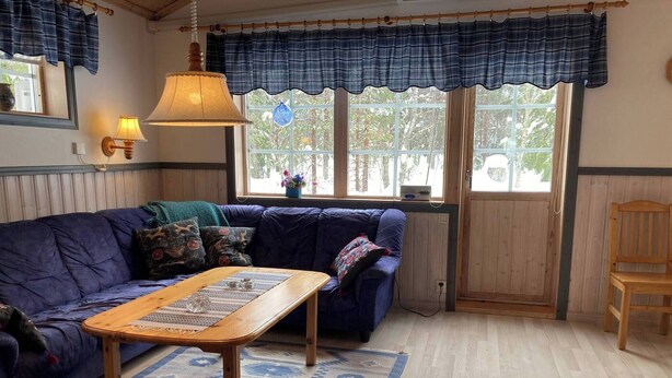 A cozy room with a blue sofa, a wooden coffee table, and a patterned rug. - beautiful mountains in Sälen högfjället Sweden (Sälen)