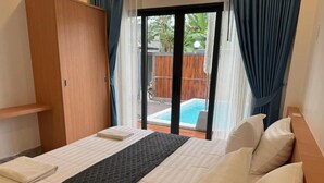 Une chambre d’hôtel avec un lit, une armoire en bois et une porte-fenêtre coulissante donnant sur l’espace piscine.