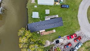 A residential area with a house, a dock, and several parked cars. - Amazing little fishing cabin on the water with a boat ramp in Everglades City (Everglades City)