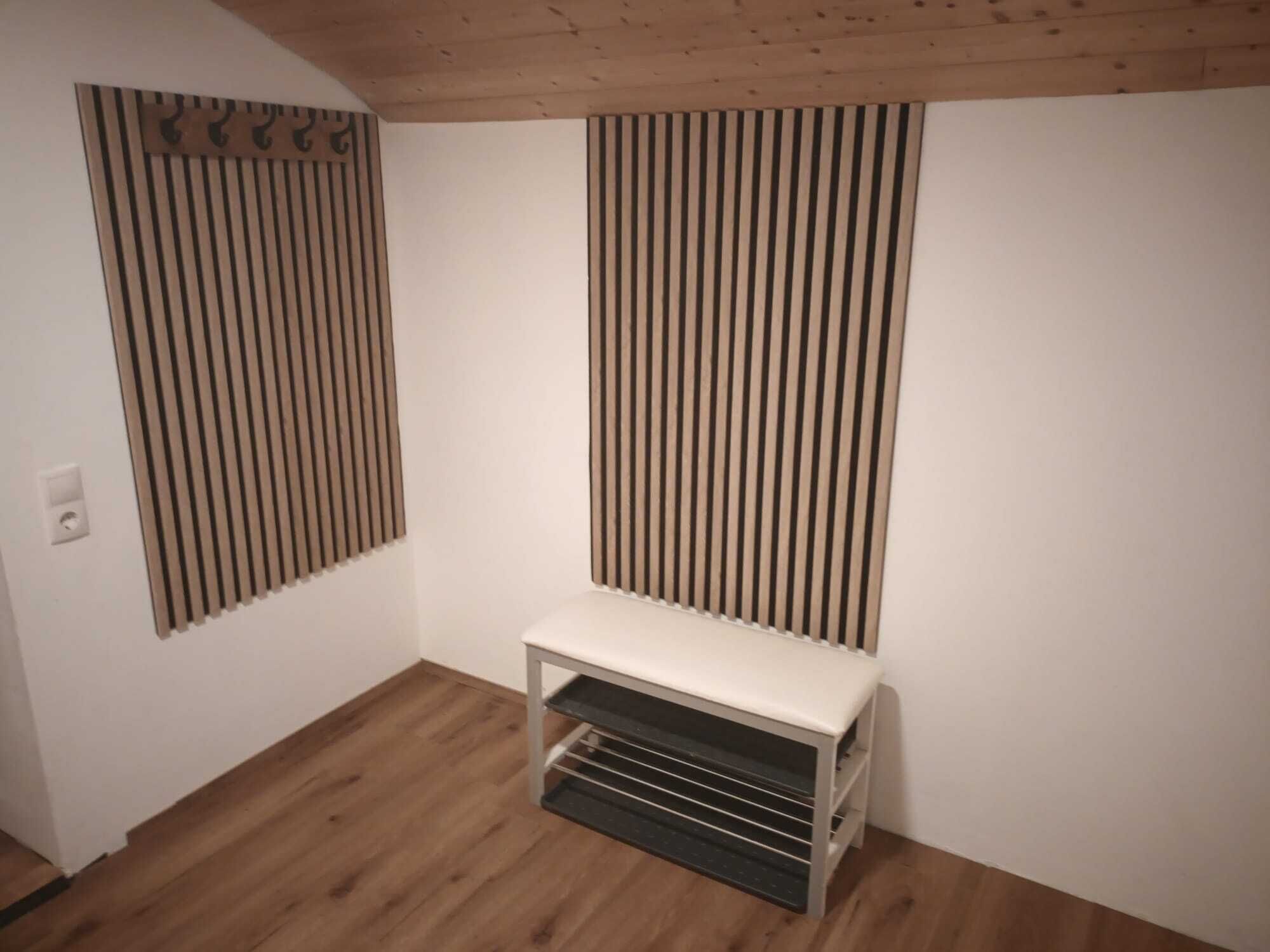 Ein Zimmer mit Holzboden, einer weißen Bank und vertikalen Rollläden an den Wänden.
