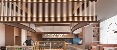 A modern interior with a central counter, seating area, and a staircase.