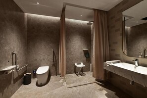A modern bathroom with a shower, toilet, and sink.