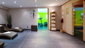 A spa area with seating, a reception desk, a phone, a plant, and exercise equipment. - Voco Dusseldorf Seestern An Ihg Hotel (Düsseldorf)
