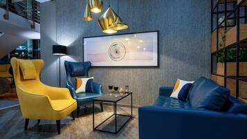Een moderne zithoek met een bank, fauteuil en salontafel.