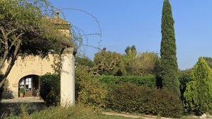 A building with a traditional architectural style, featuring a stone archway and a small garden area with a pathway.