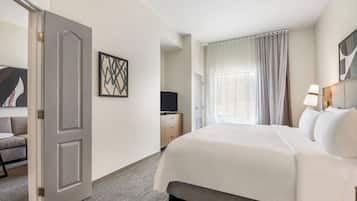 Una habitación de hotel con cama, televisión, escritorio y puerta.