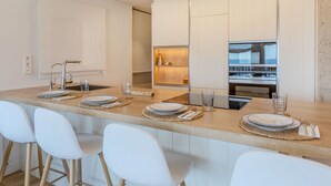 Eine moderne Küche mit Kochinsel, Barhocker und eingebautem Backofen.