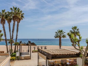 Ein Strandhotel mit Palmen, Außenbereich und Meerblick.
