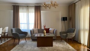 Un soggiorno moderno con un divano grigio, due poltrone, un tavolino e una lampada da terra.