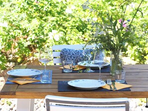 A wooden table set with blue and white plates, clear glasses, and a vase with flowers. - A Gem on the Peenestrom: 125 m² of living space, nature, tranquility, biking, fishing, hiking (Quilitz)