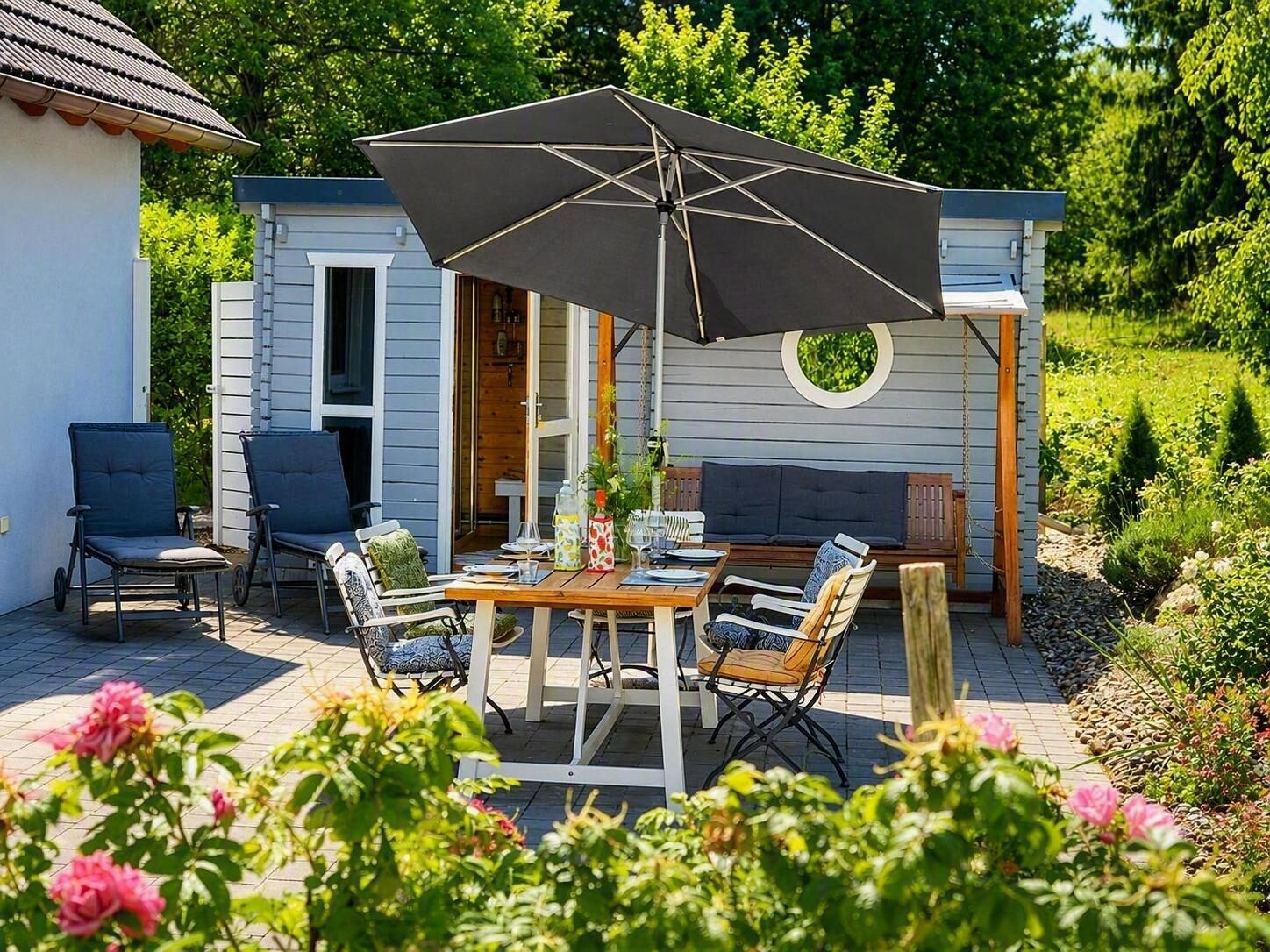 An outdoor patio with a table, chairs, and an umbrella.