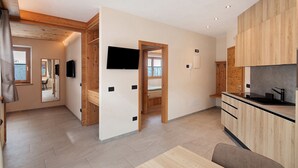 Een moderne keuken met houten kastjes, een zwart aanrecht en een inbouwoven.