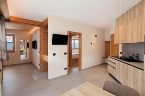 Une cuisine moderne avec des meubles en bois, un plan de travail noir et un four encastré.