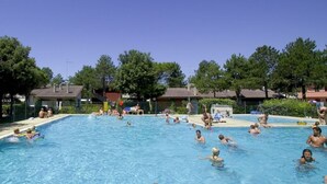 Ein Schwimmbad, umgeben von Bäumen und Gebäuden.