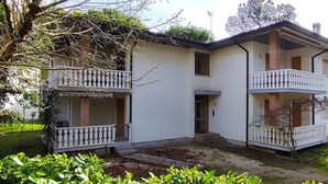 Een gebouw met twee verdiepingen, een balkon op de begane grond en een balkon op de tweede verdieping.