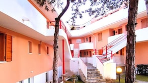 Un edificio de varios niveles con escaleras, asientos exteriores y un césped bien cuidado.