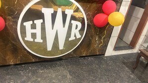 Ein Empfangsschalter mit Marmorplatte und einem großen, runden Schild mit der Aufschrift 'HWR'.