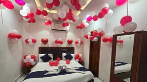 Ein Hotelzimmer mit einem Bett, einem Spiegel und roten und weißen Luftballons.
