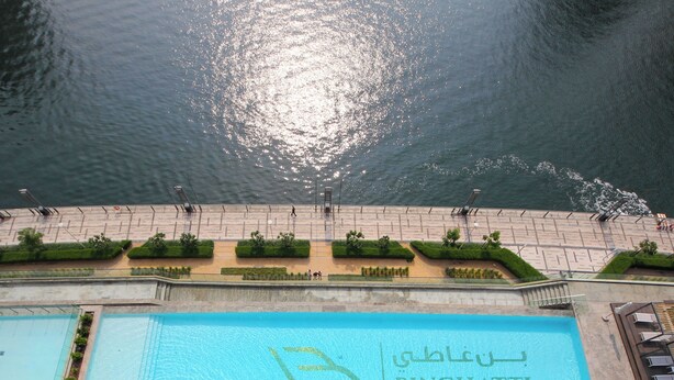 A swimming pool with the name "BINGHATI" and a view of the water body in the background. - Studio in Trillionaire - Private Jacuzzi (Dubai)