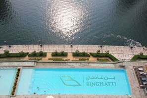 Ein Schwimmbecken mit der Bezeichnung „BINGHATI“ und Blick auf ein angrenzendes Gewässer im Hintergrund.