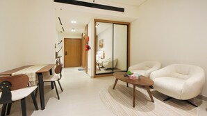 A modern living room with a dining table, two chairs, a sofa, and a coffee table. - Studio in Trillionaire - Private Jacuzzi (Dubai)