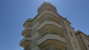 A multi-story building with a modern architectural design, featuring balconies on each floor. - SE225 – Senigallia, sea view apartment with parking (Senigallia)